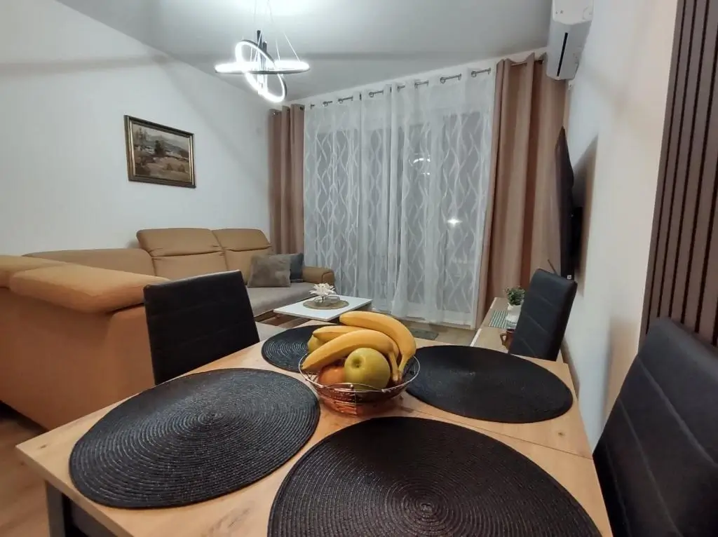 Trpezarijski sto sa stolicama u dnevnoj sobi apartmana Jeca